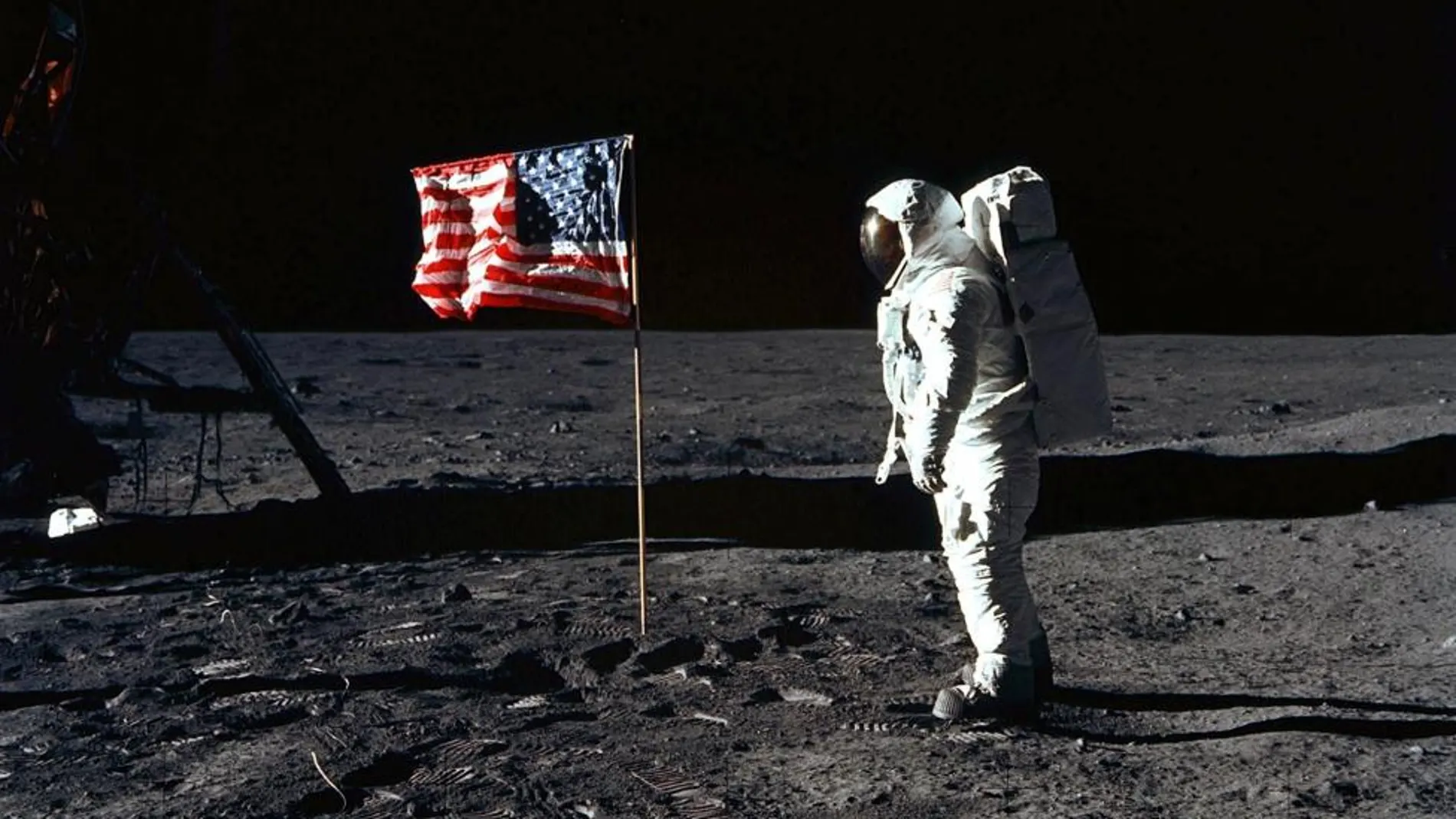 El primero en pisar la superficie lunar es Neil Armstrong y, poco después, lo hace Edwin Aldrin, mientras que Michael Collins permanece en la nave. En la foto, Aldrin posa para una fotografía junto a la bandera estadounidense, 20 de julio 1969.