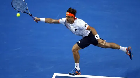 El tenista español David Ferrer devuelve la bola al estadounidense John Isner.