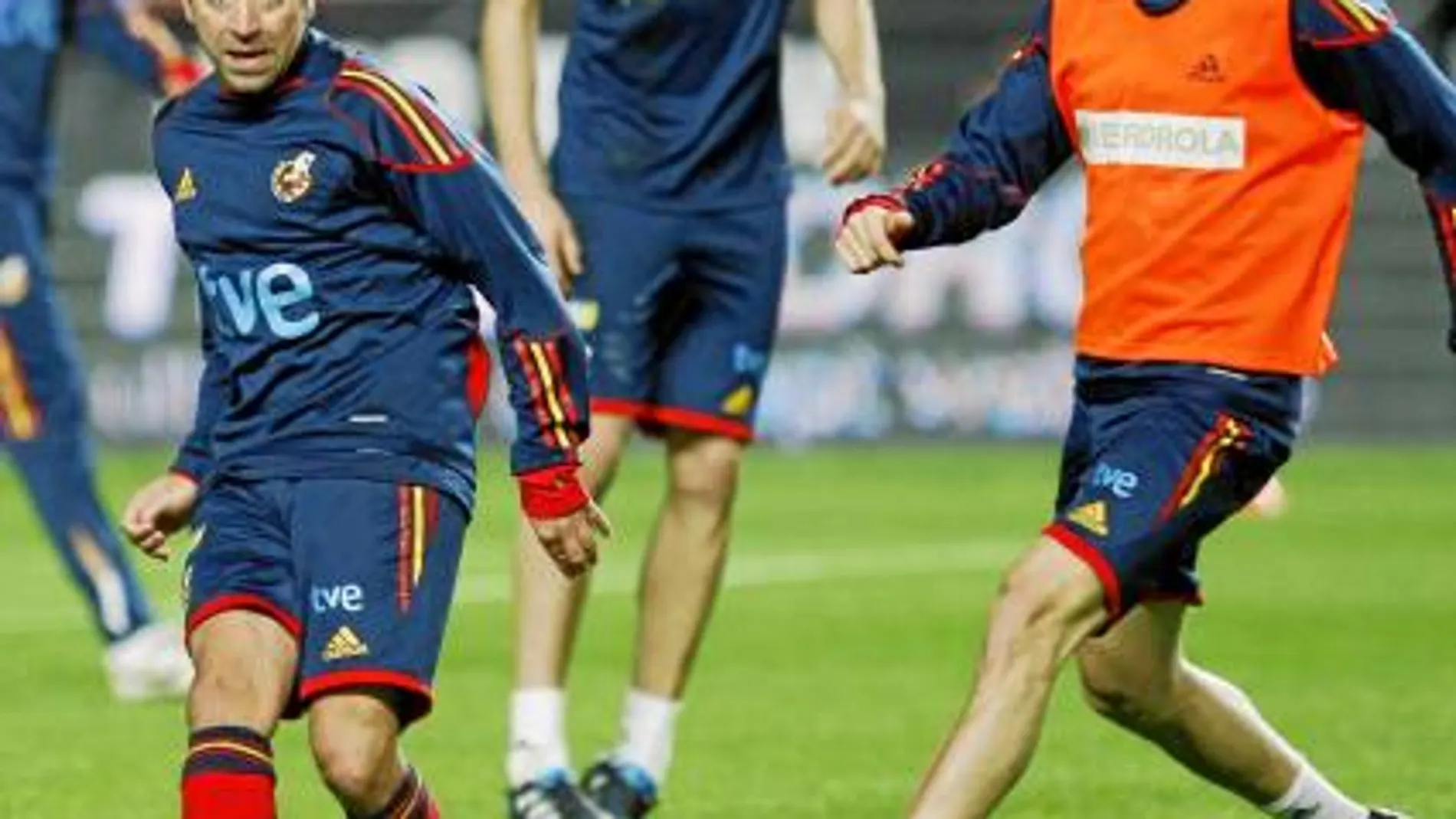 Xavi, que «puede jugar 90 minutos», según Del Bosque, da un pase en el entrenamiento presionado por Cesc