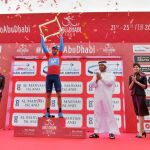 Alejandro Valverde, en el podio vestido con el maillot rojo que distingue al primer clasificado, levanta el trofeo como ganador en Abu Dabi
