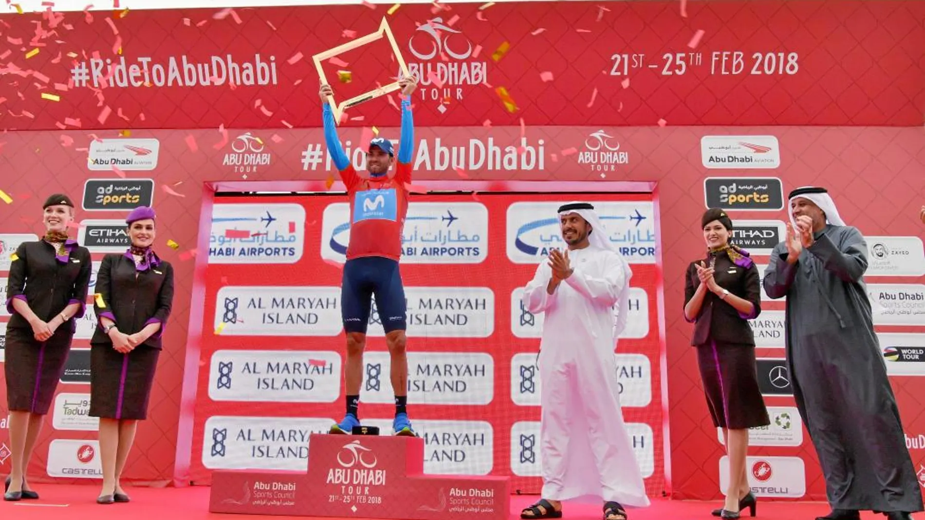 Alejandro Valverde, en el podio vestido con el maillot rojo que distingue al primer clasificado, levanta el trofeo como ganador en Abu Dabi