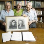 Jesús Cansado (86), su hijo Francisco (57) y su hermano mayor Pascual (95) posan junto al retrato de su padre, José Cansado, fusilado en 1936, y su madre, Manuela. Foto: Jesús G. Feria