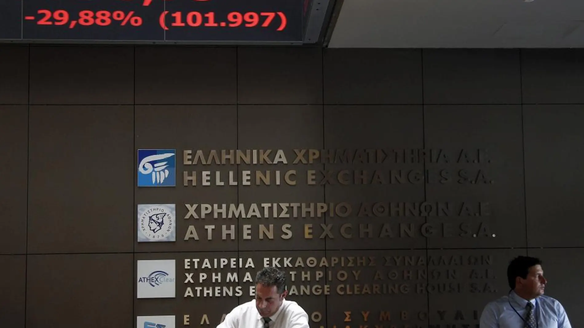 Agentes de Bolsa realizan su trabajo en el parqué de Atenas en Grecia