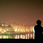 Una pareja disfruta de la vista nocturna de la ciudad de San Sebastián desde el Aquarium.