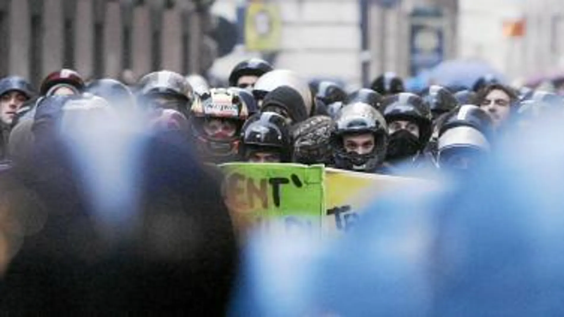 Los estudiantes, con cascos de moto, se encaran a la Policía en la manifestación de ayer, en Roma