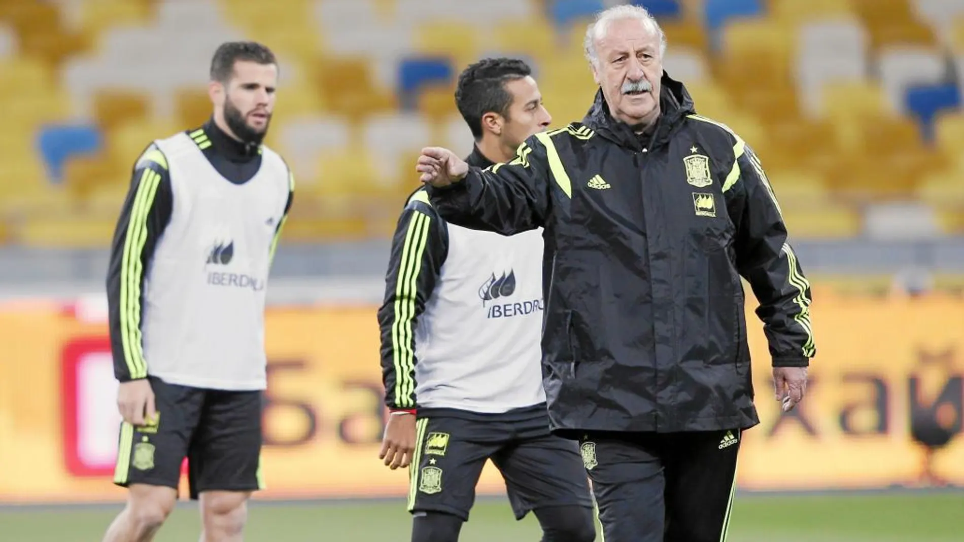 Del Bosque da instrucciones a sus jugadores, con Nacho y Thiago detrás, durante el entrenamiento de ayer