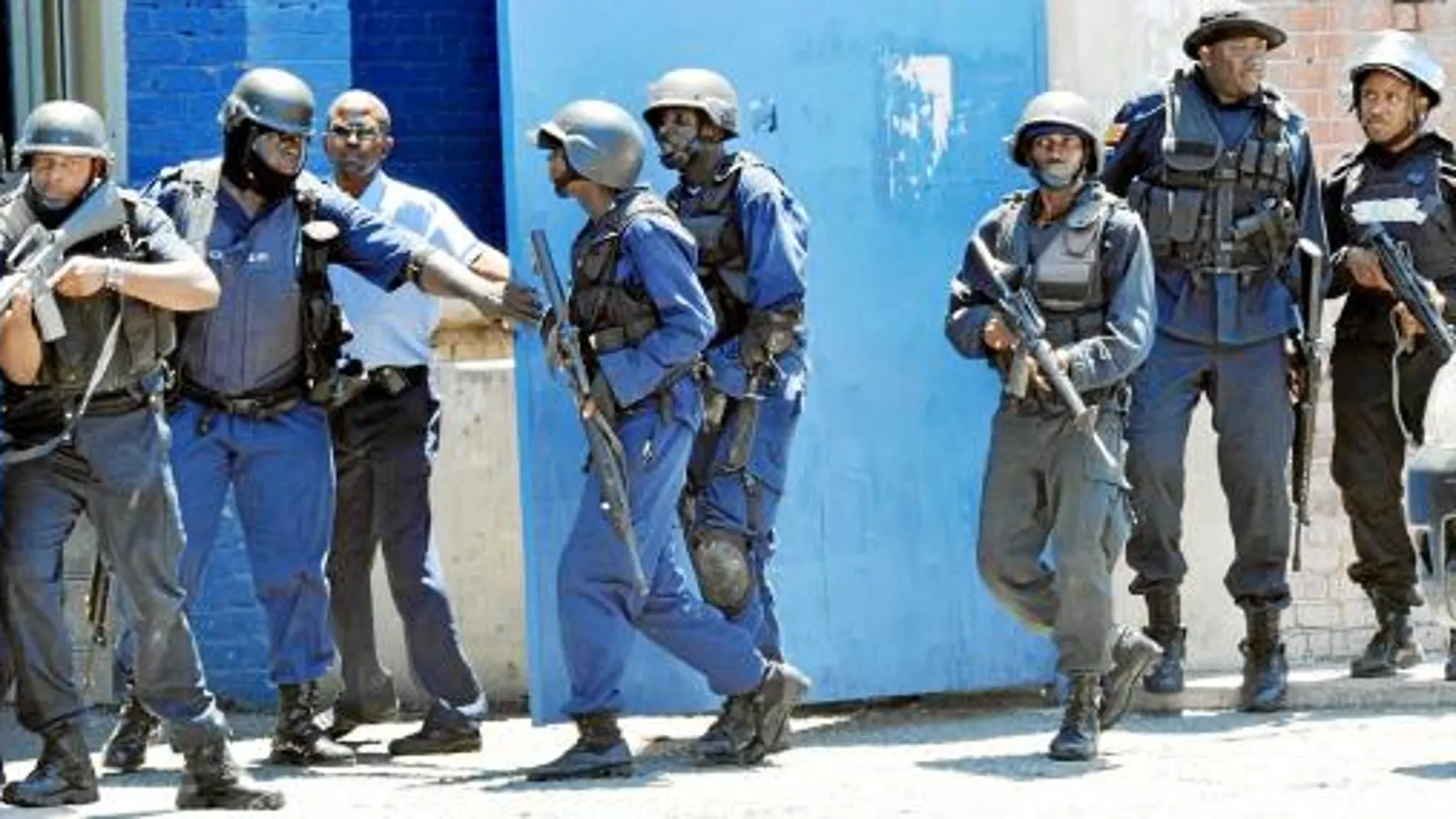 Policías y soldados, armados con rifles, merodean la conflictiva zona de Tivoli Gardens buscando a Coke