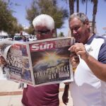 Unos británicos leen la portada del periódico "The Sun"en Mijas Costa en Málaga