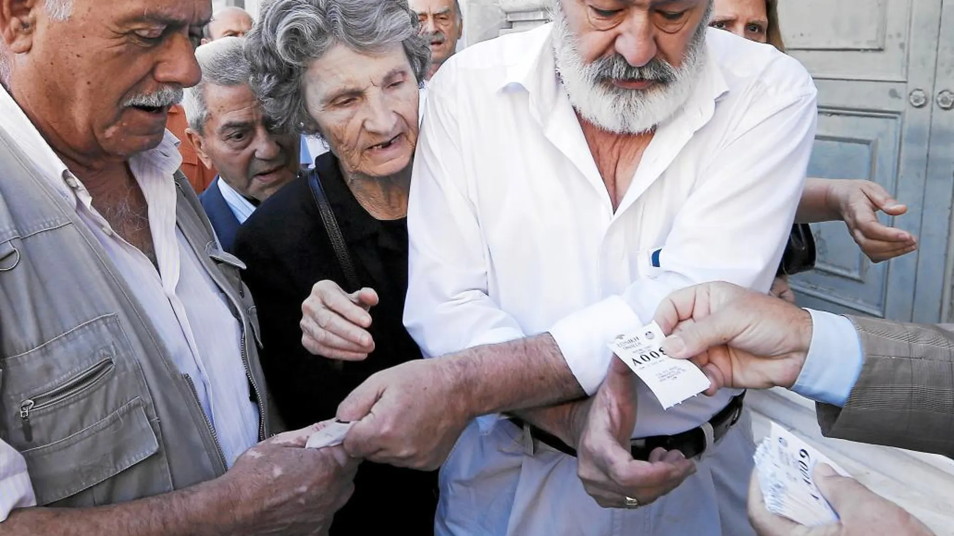 Reparto de números a los pensionistas griegos para poder cobrar parte de sus pensiones, ayer, en Atenas
