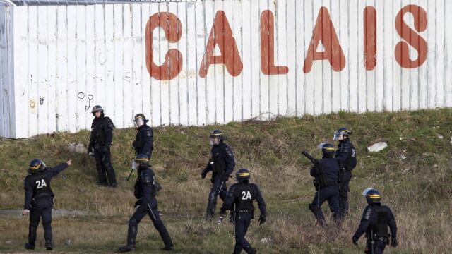 La policía francesa persigue a inmigrantes en e puerto de Calais.