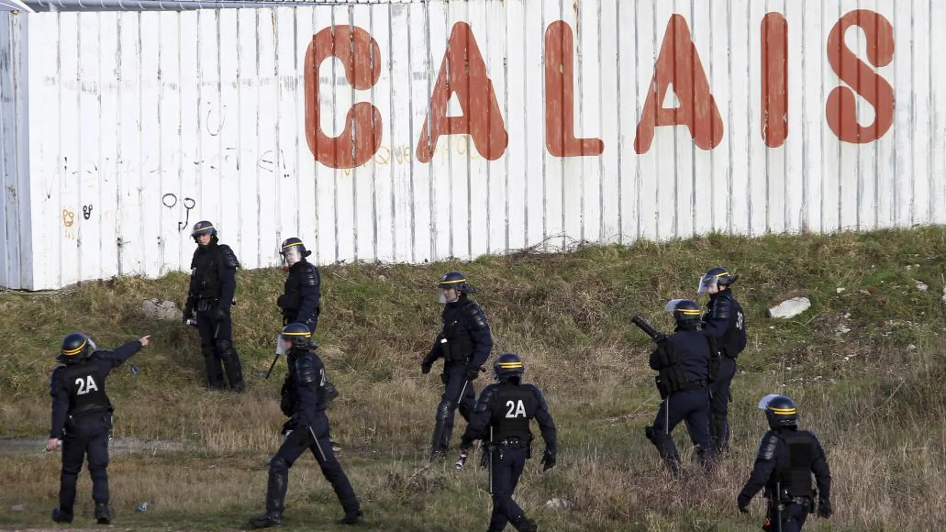 La policía francesa persigue a inmigrantes en e puerto de Calais.