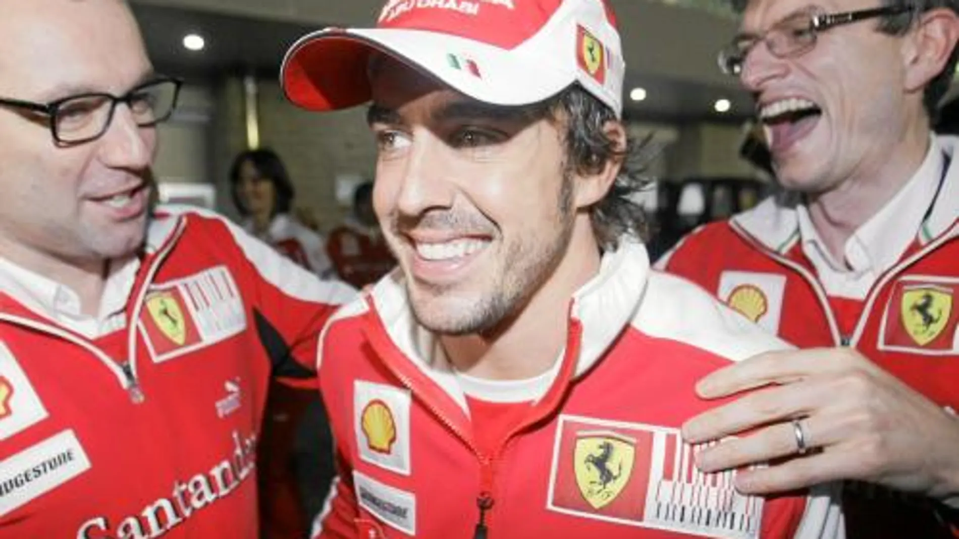 Fernando Alonso, con dos de los ingenieros de la escudería la pasada temporada