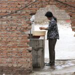 Una mujer se lava las manos en un barreño de agua en Pekín (China)