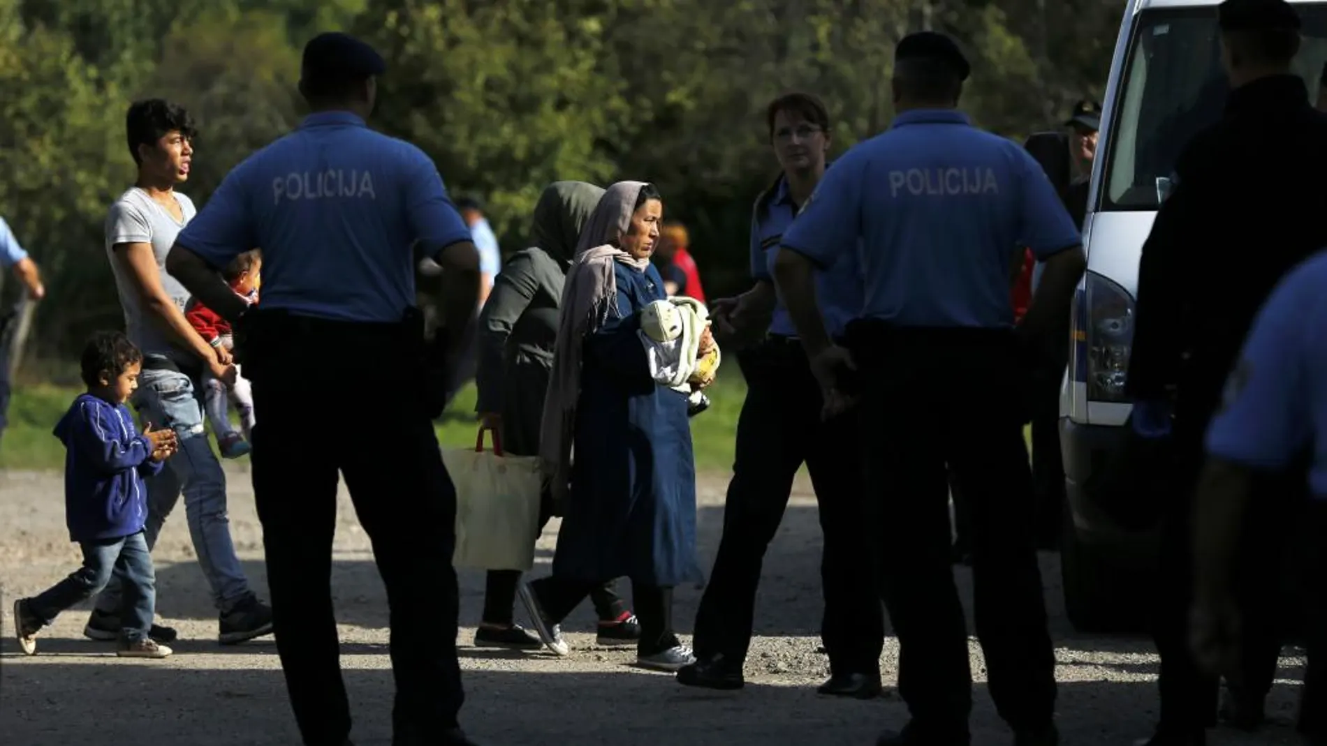 Un grupo de refugiados escoltados por la policía croata.