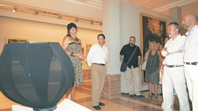La artista belga, Monique Bastiaans, enseña y comenta con sus admiradores una de sus obras