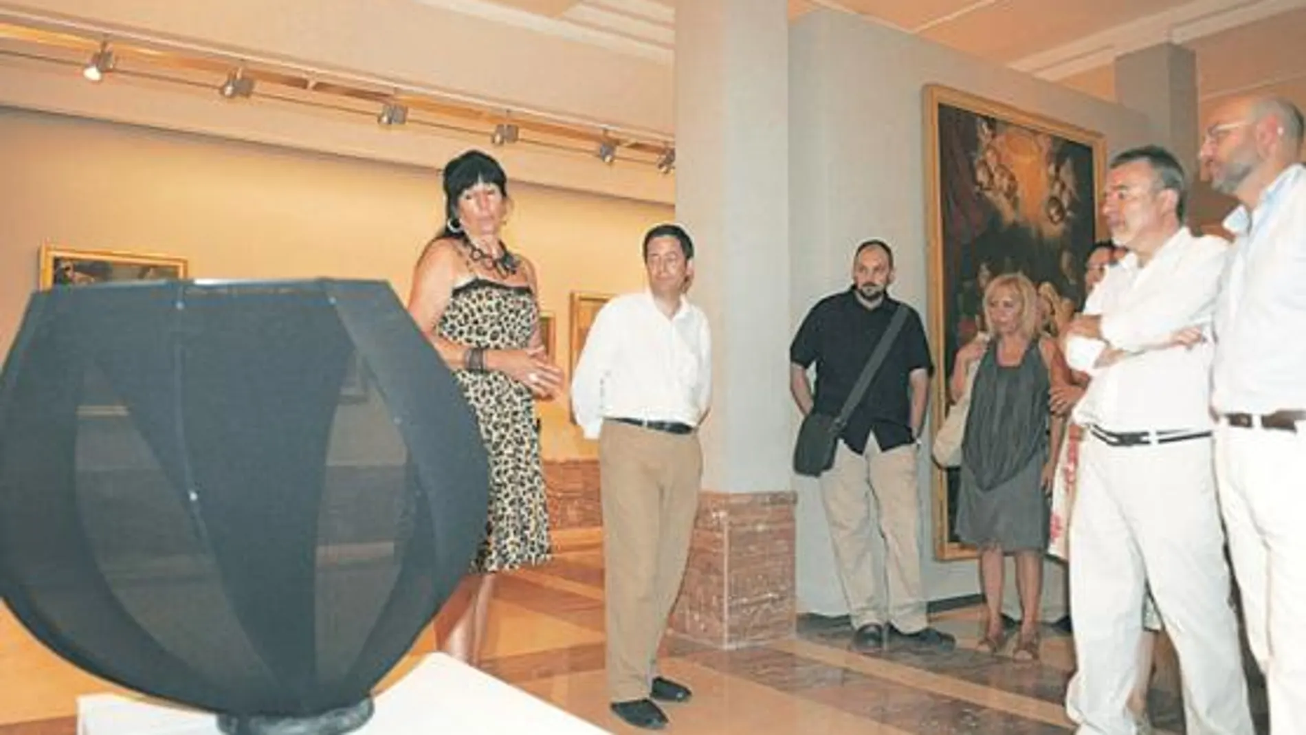La artista belga, Monique Bastiaans, enseña y comenta con sus admiradores una de sus obras