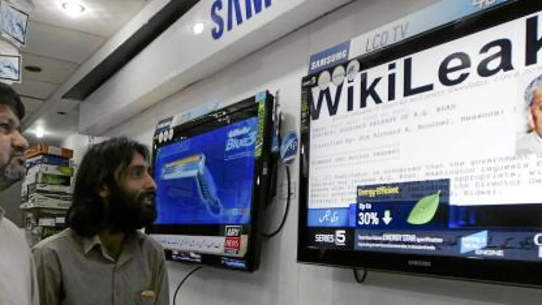 Dos paquistaníes escuchan las noticias de Wikileaks, ayer, en una tienda en Karachi