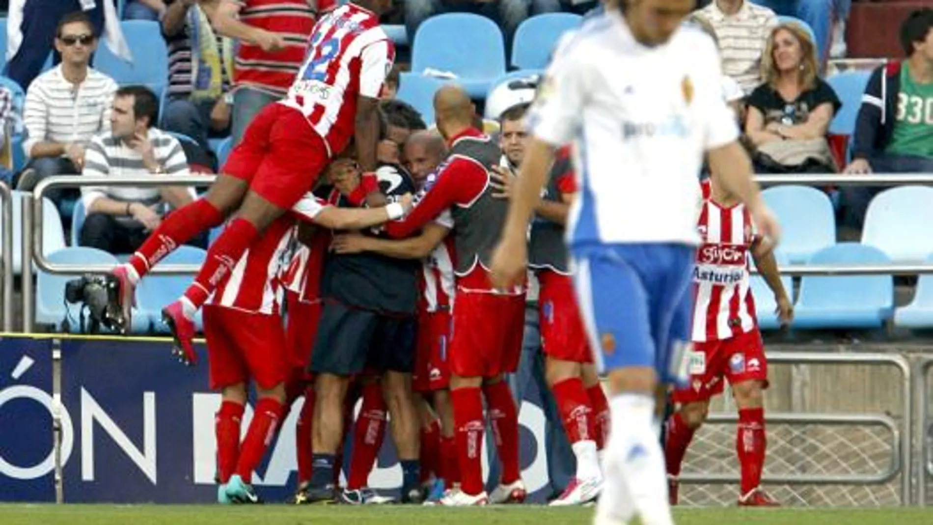 Los jugadores del Sporting de Gijón (al fondo) celebran su segundo gol, materializado por el delantero Diego Castro