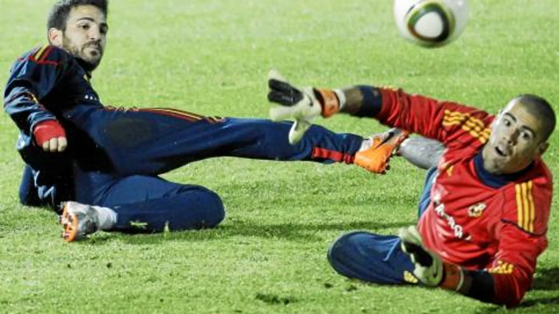 Cesc trata de meter un gol a Valdés en el entrenamiento de ayer