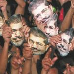 Decenas de seguidores visten máscaras con el rostro del presidente Mursi durante una manifestación el 12 de julio de 2013/Reuters