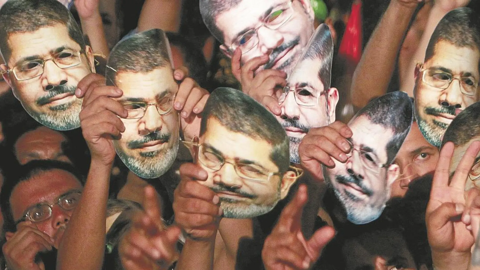 Decenas de seguidores visten máscaras con el rostro del presidente Mursi durante una manifestación el 12 de julio de 2013/Reuters