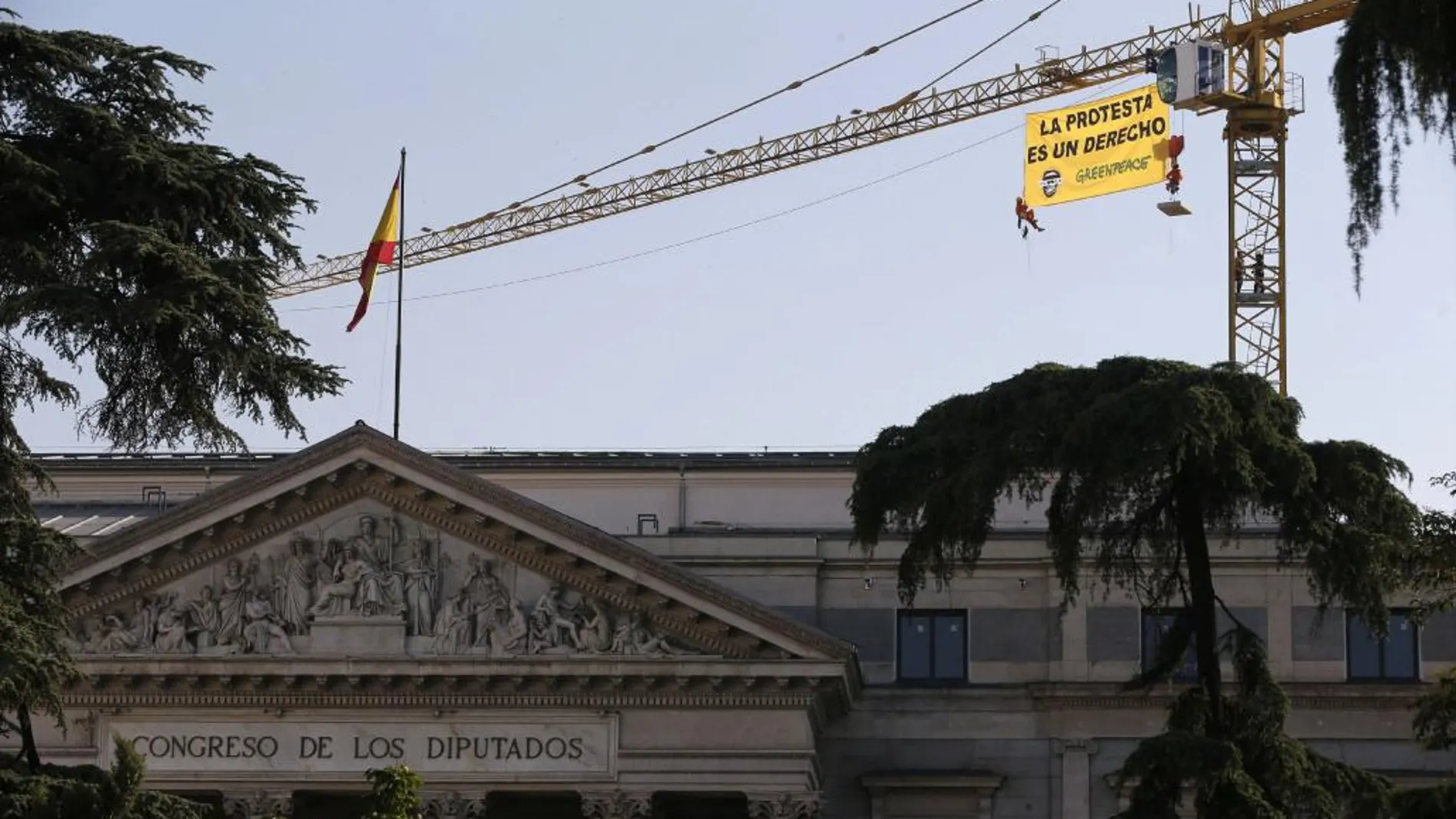 Tres activistas de Greenpeace han desplegado hoy una pancarta de 32 metros cuadrados en una grúa situada junto al Congreso de los Diputados contra la que denominan "ley mordaza", en referencia a la ley de seguridad ciudadana que entrará mañana en vigor.