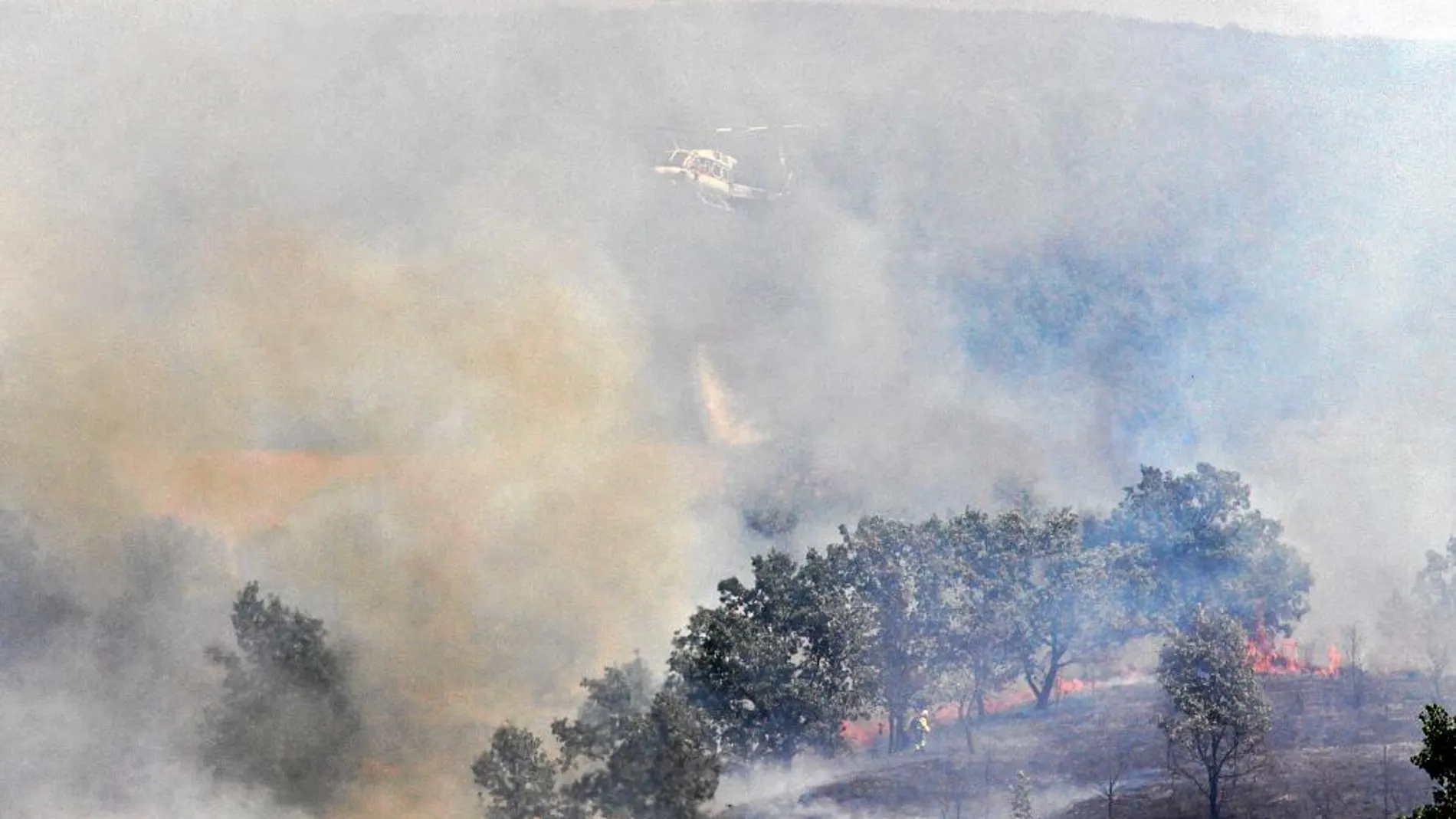 Un helicóptero sobrevuela la zona del incendio en Carbajal de la Legua, que fue extinguido ayer