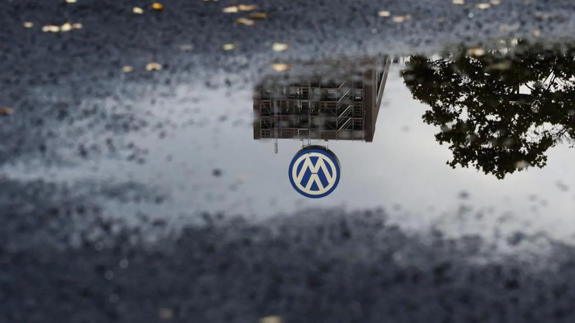El logotipo de Volkswagen se refleja en un charco en el parking de empleados de la compañía en Wolfsburgo