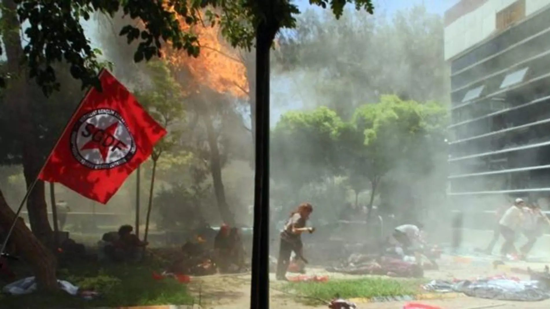 Varias personas corren para ponerse a salvo tras producirse la explosión de un artefacto en un centro cultural en Suruc (Turquía).