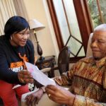 Nelson Mandela lee una carta junto a Zindzi, en su casa en Johannesburgo, la víspera de su cumpleaños