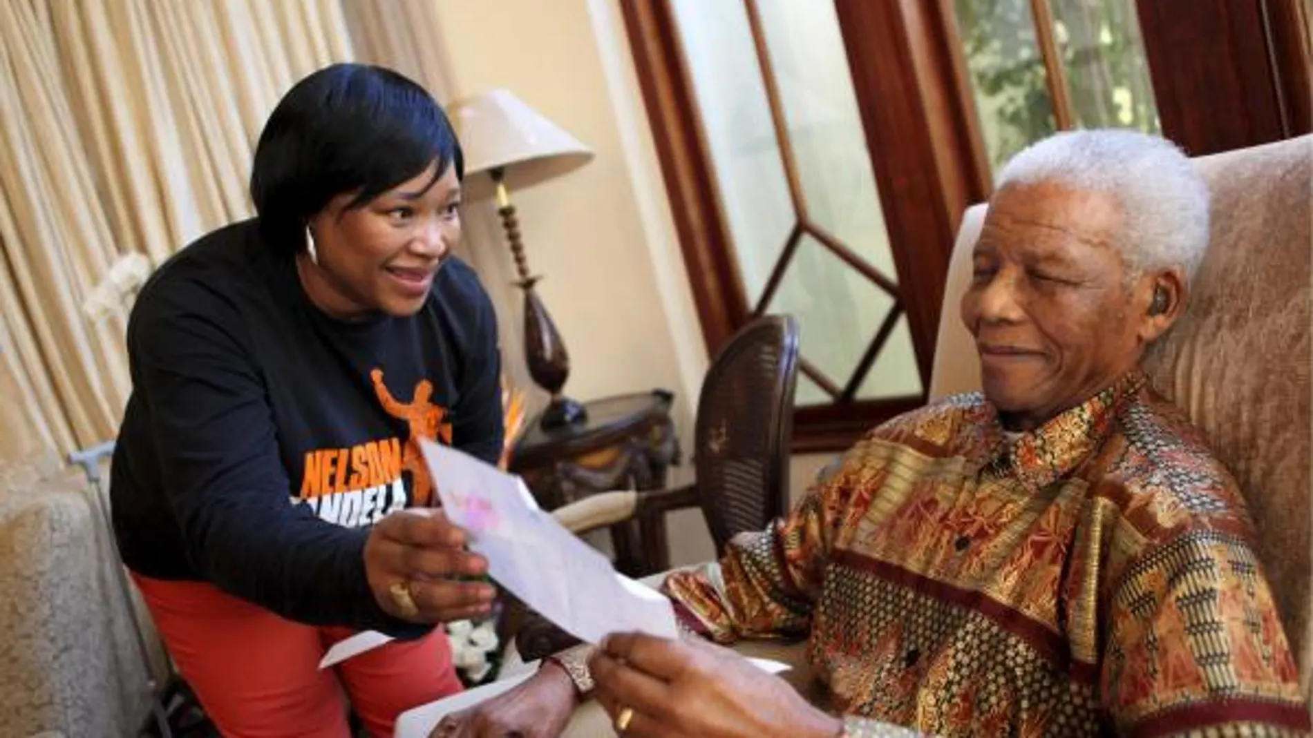 Nelson Mandela lee una carta junto a Zindzi, en su casa en Johannesburgo, la víspera de su cumpleaños