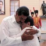 El candidato chavista, Nicolás Maduro, abraza a Maradona ante el sarcófago que contiene los restos de Chávez, ayer en Caracas