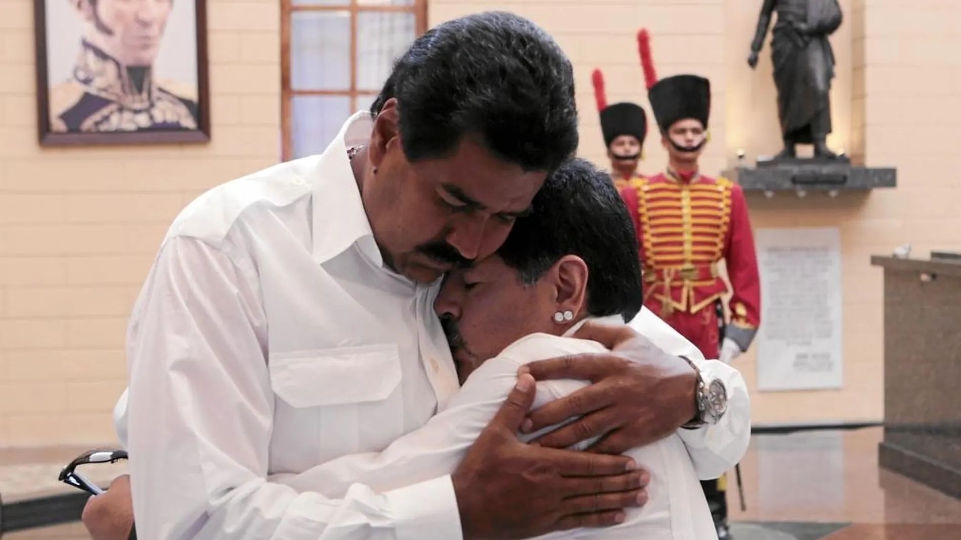 El candidato chavista, Nicolás Maduro, abraza a Maradona ante el sarcófago que contiene los restos de Chávez, ayer en Caracas