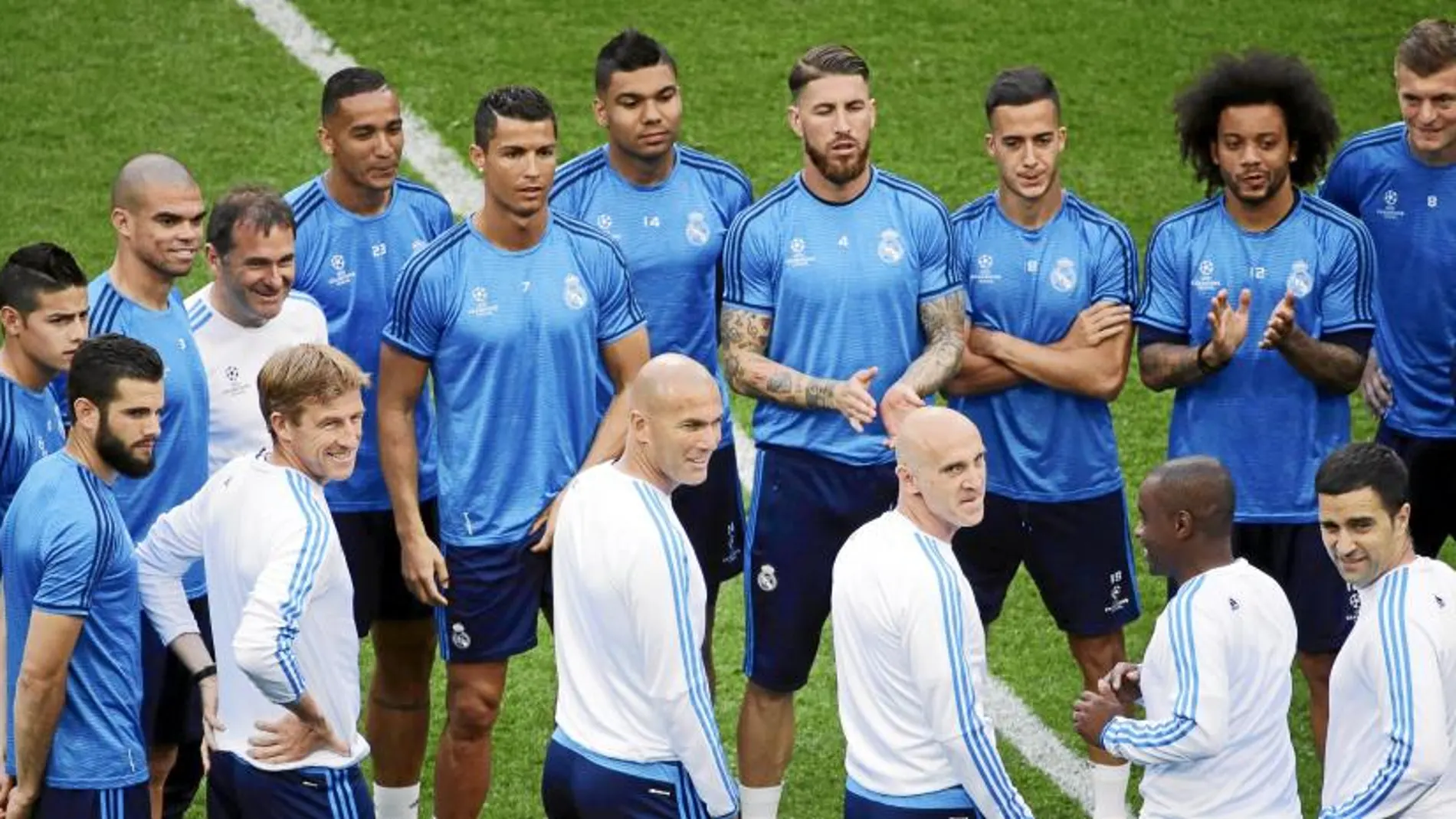 Zidane, su cuerpo técnico y los jugadores, en la reunión previa al entrenamiento ayer sobre el césped de San Siro