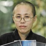 La mujer del destacado defensor de los Derechos Humanos en China, Liu Xia, sostiene las fotos de su marido encarcelado, Liu Xiaobo
