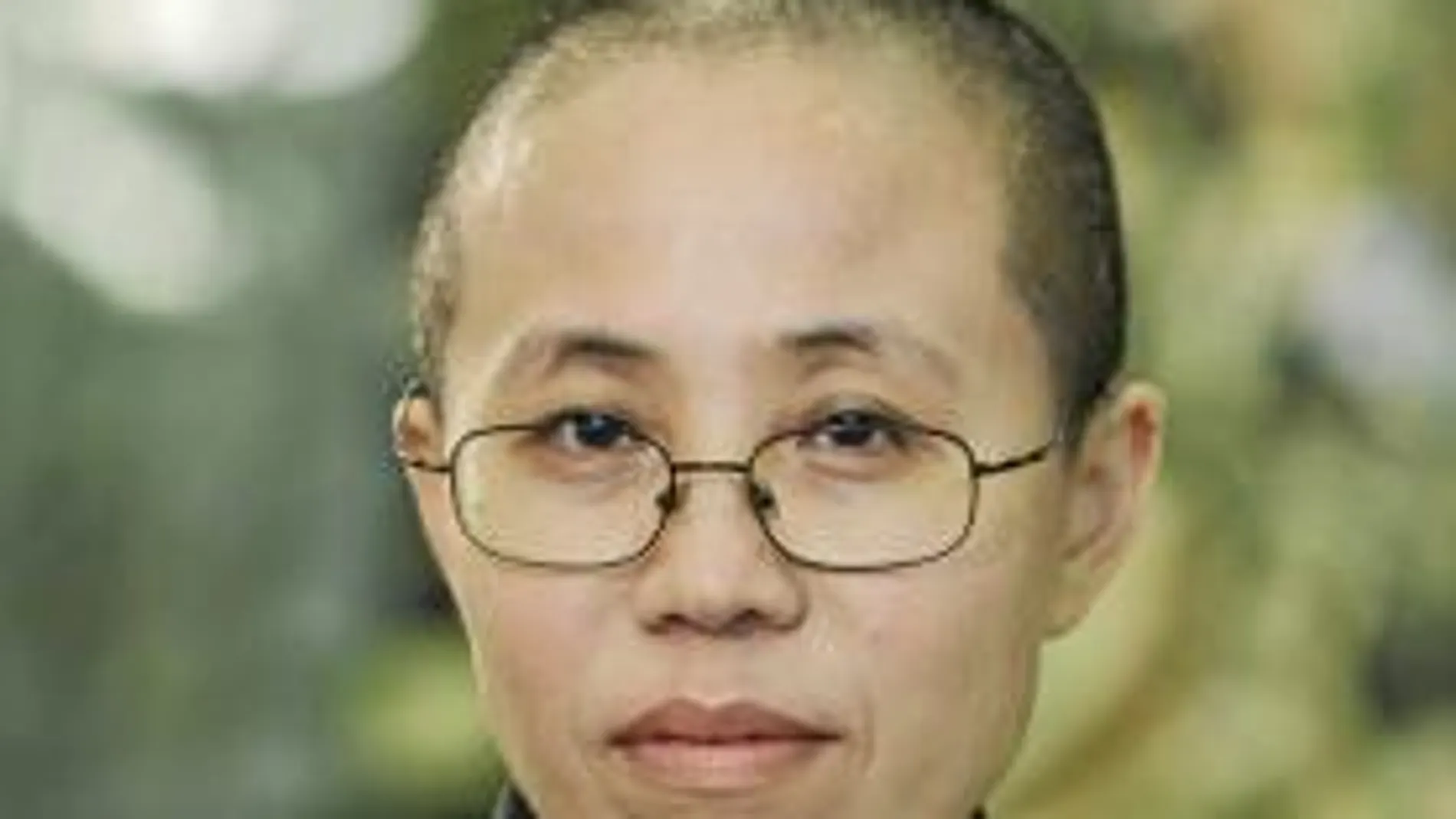 La mujer del destacado defensor de los Derechos Humanos en China, Liu Xia, sostiene las fotos de su marido encarcelado, Liu Xiaobo