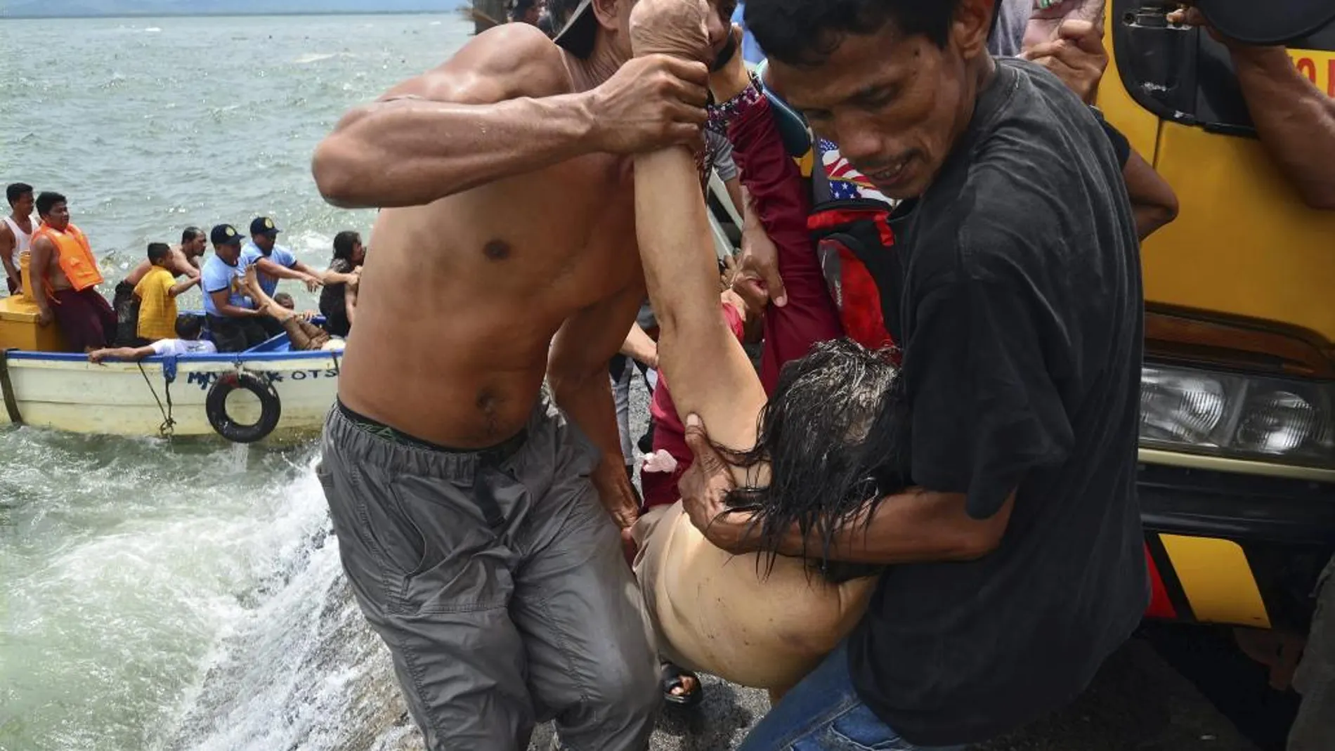 Varias personas sacan el cadáver de uno de los pasajeros.