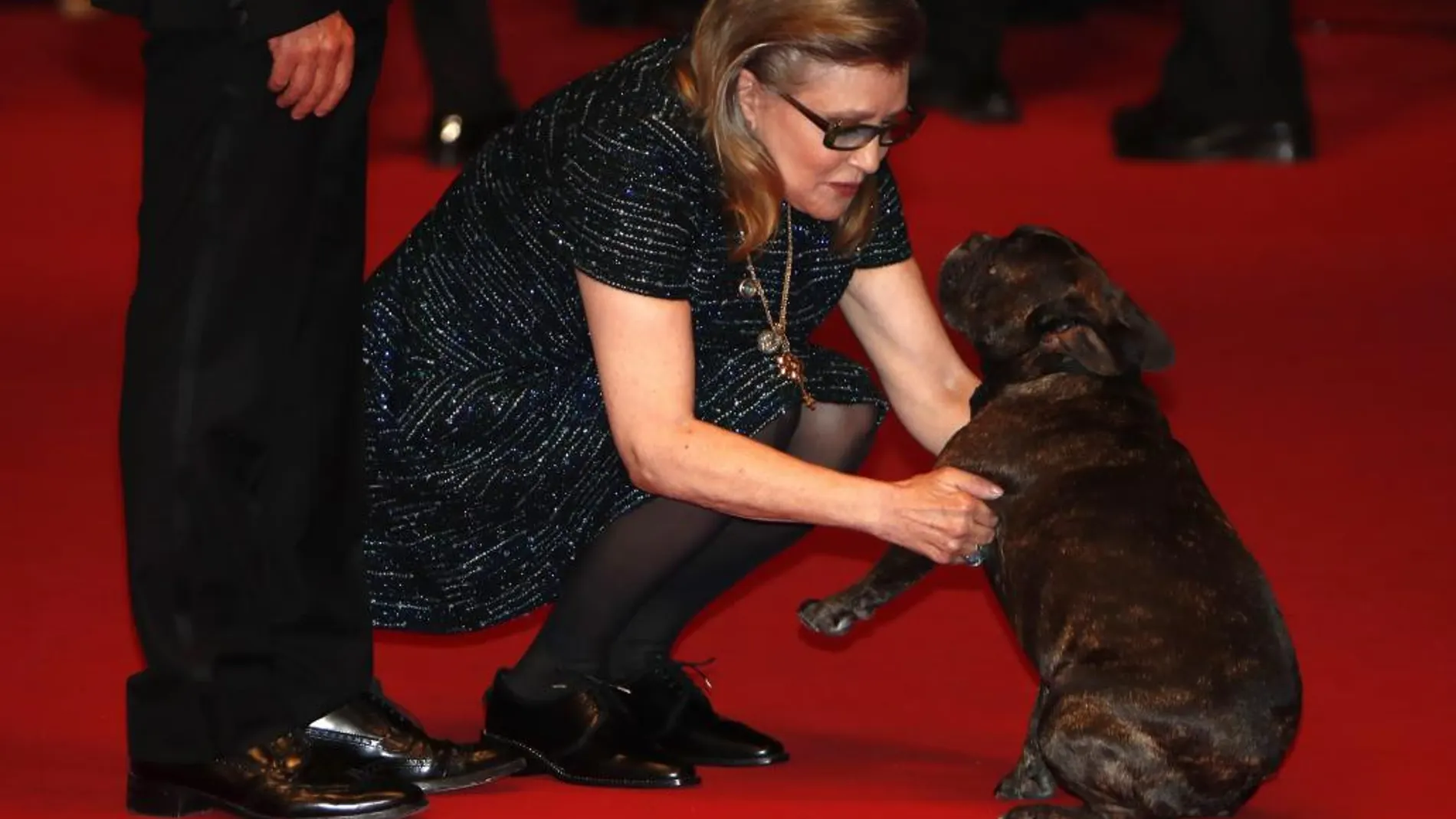 La actriz Carrie Fisher jugando con su perro en la 69 edición del Festival de de Cannes