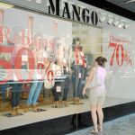 Una joven mira algunas de las prendas expuestas en un escaparate de una tienda en la ciudad de Murcia