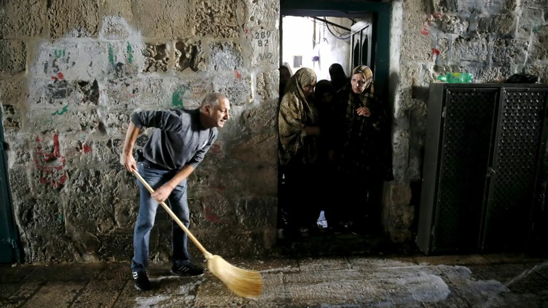 Un hombre limpia sangre en el lugar del suceso tras un ataque en el que se vio implicada una mujer palestina y un israelí en el casco viejo de Jerusalén