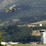 Un avión despega esta tarde ante la torre de control del aeropuerto de Bilbao