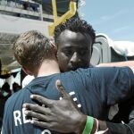 Un inmigrante y un voluntario se abrazan tras llegar a tierra