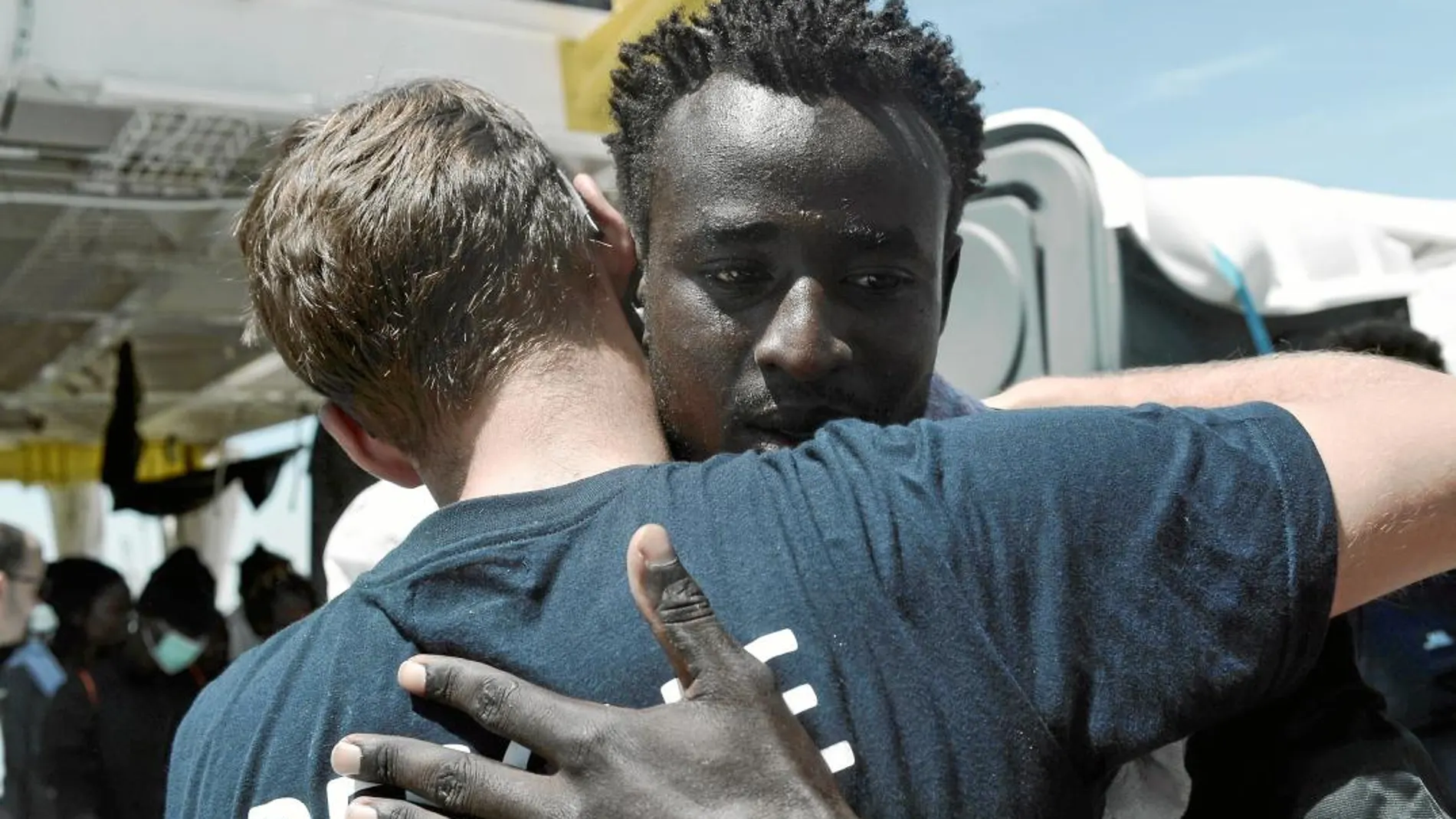 Un inmigrante y un voluntario se abrazan tras llegar a tierra