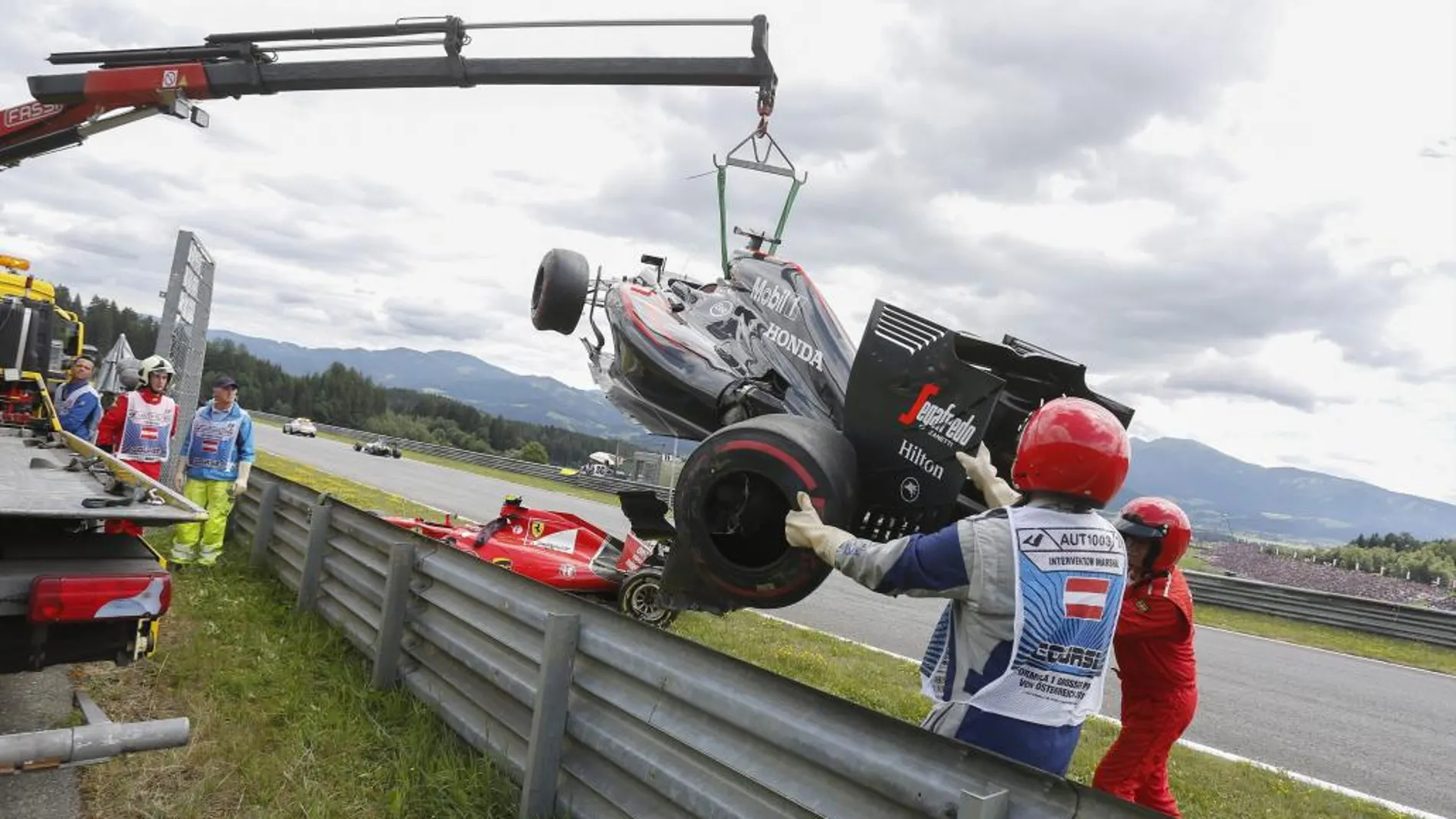 El monoplaza de Fernando Alonso es retirado de la pista tras el accidente sufrido con Raikkonen