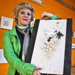 La artista Lidia Calvo, muestra una de sus obras pintadas con vino que forma parte de un proyecto denominado "Boluarte"