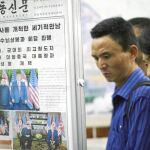 Los norcoreanos leen los periódicos con Trump y Kim en la portada, ayer en la estación de Puhung del metro de Pyongyang