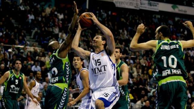 El base del Real Madrid Jorge Garbajosa realiza una entrada a canasta ante el jugador del Unicaja Blackwey
