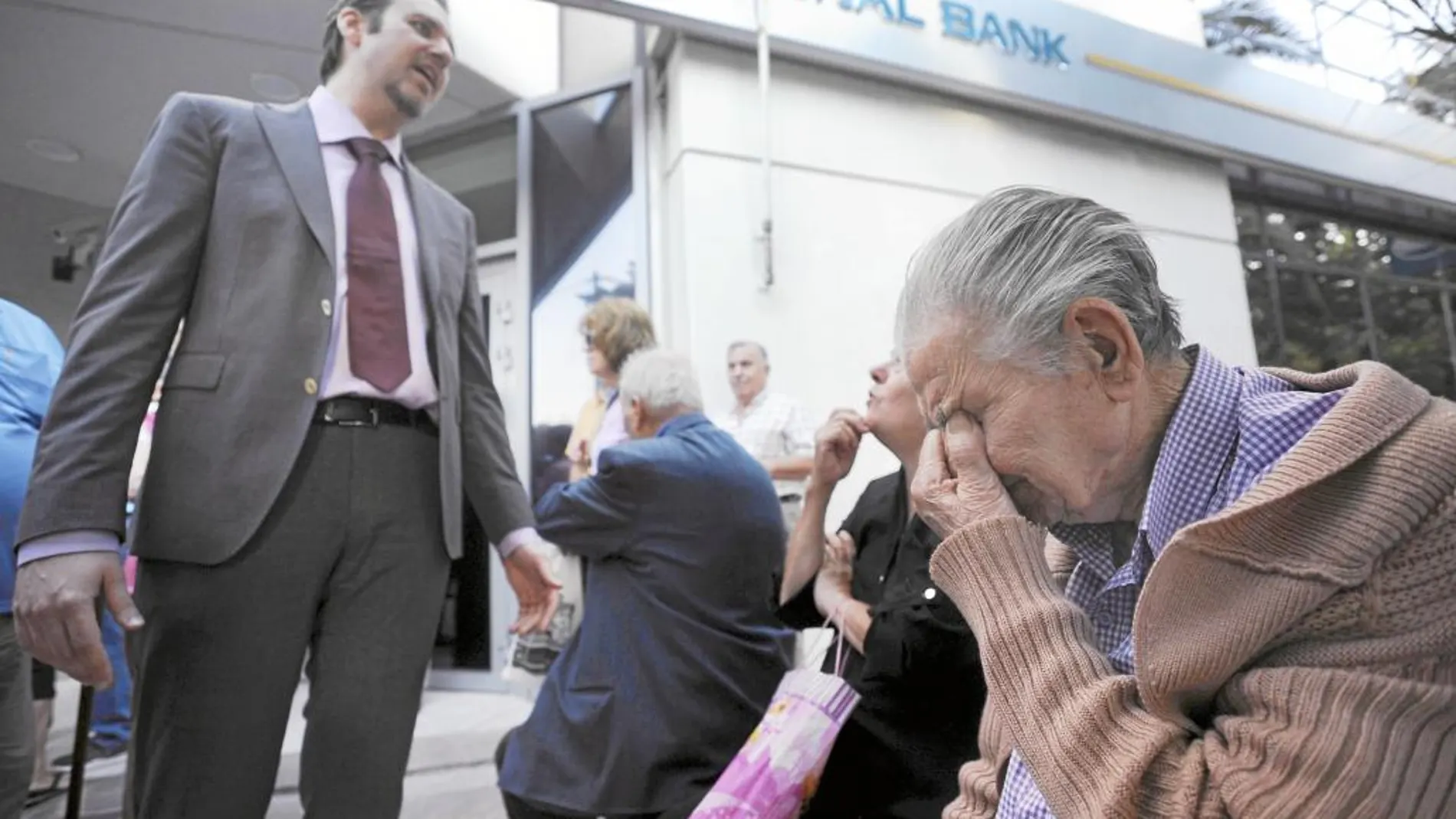 Varios pensionistas esperan a las puertas de los bancos