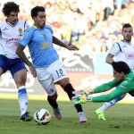 El portero marroquí del Real Zaragoza Yassine Bounou (d) intenta parar el balón ante el delantero argentino de UD Las Palmas Sergio Araujo