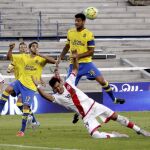 El delantero del Rayo Vallecano Javier Guerra (c) y los jugadores de Las Palmas Pedro Bigas (i) y Aythami Artiles luchan por el balón